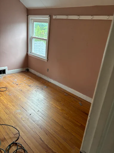Worn hardwood floor in an additional room before refinishing