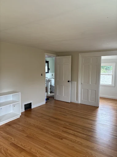 Hardwood floor in the room with built-in shelving after refinishing