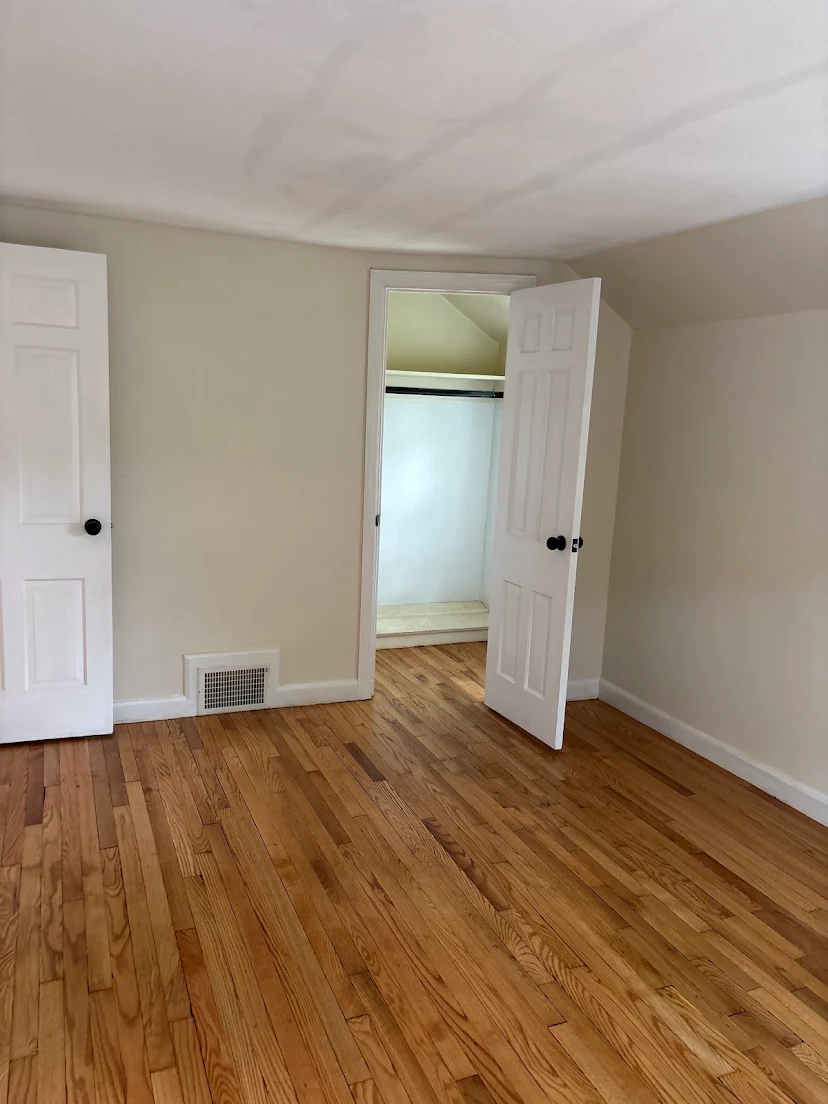 Finished hardwood floor through a bedroom doorway