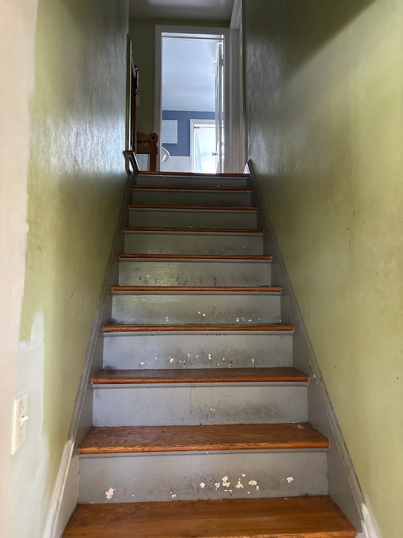 The worn staircase before tread sanding and refinishing