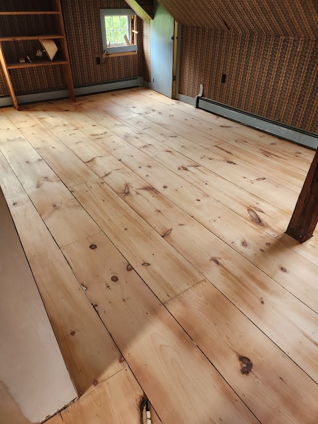 Wide white pine attic floor during the sanding process