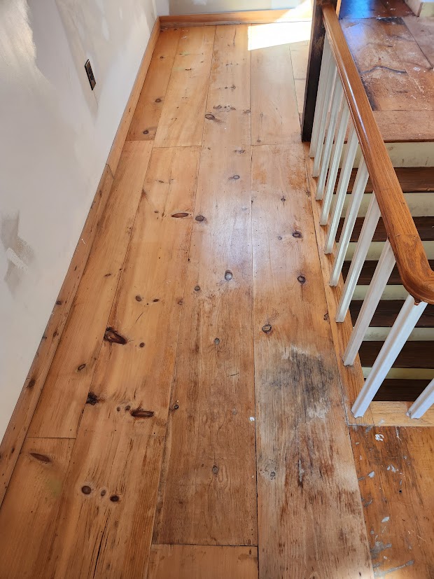Wide white pine upstairs landing before restoration
